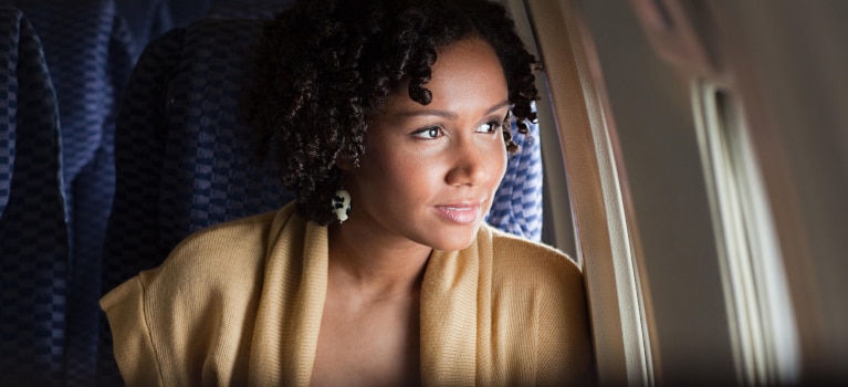 woman smiling out airplane window