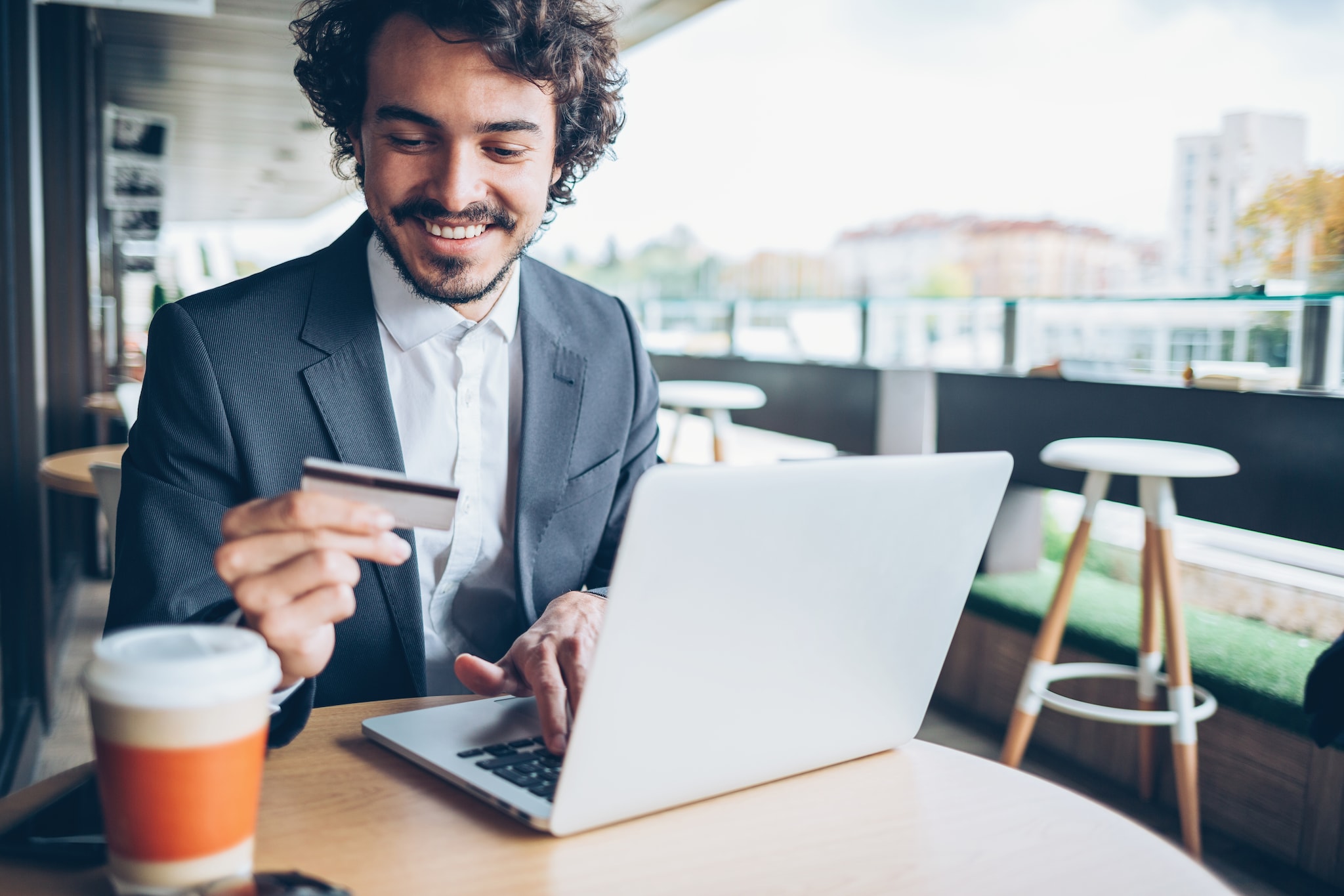 A man with a laptop looking at his Card