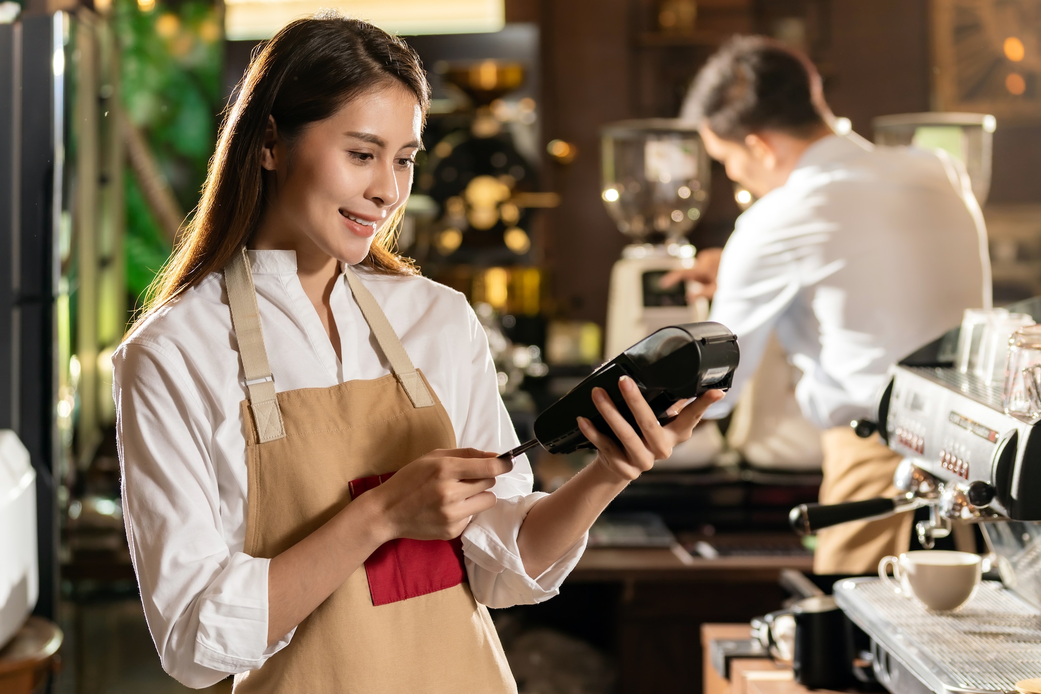 A lady inserting the Chip Card into the slot in the terminal.