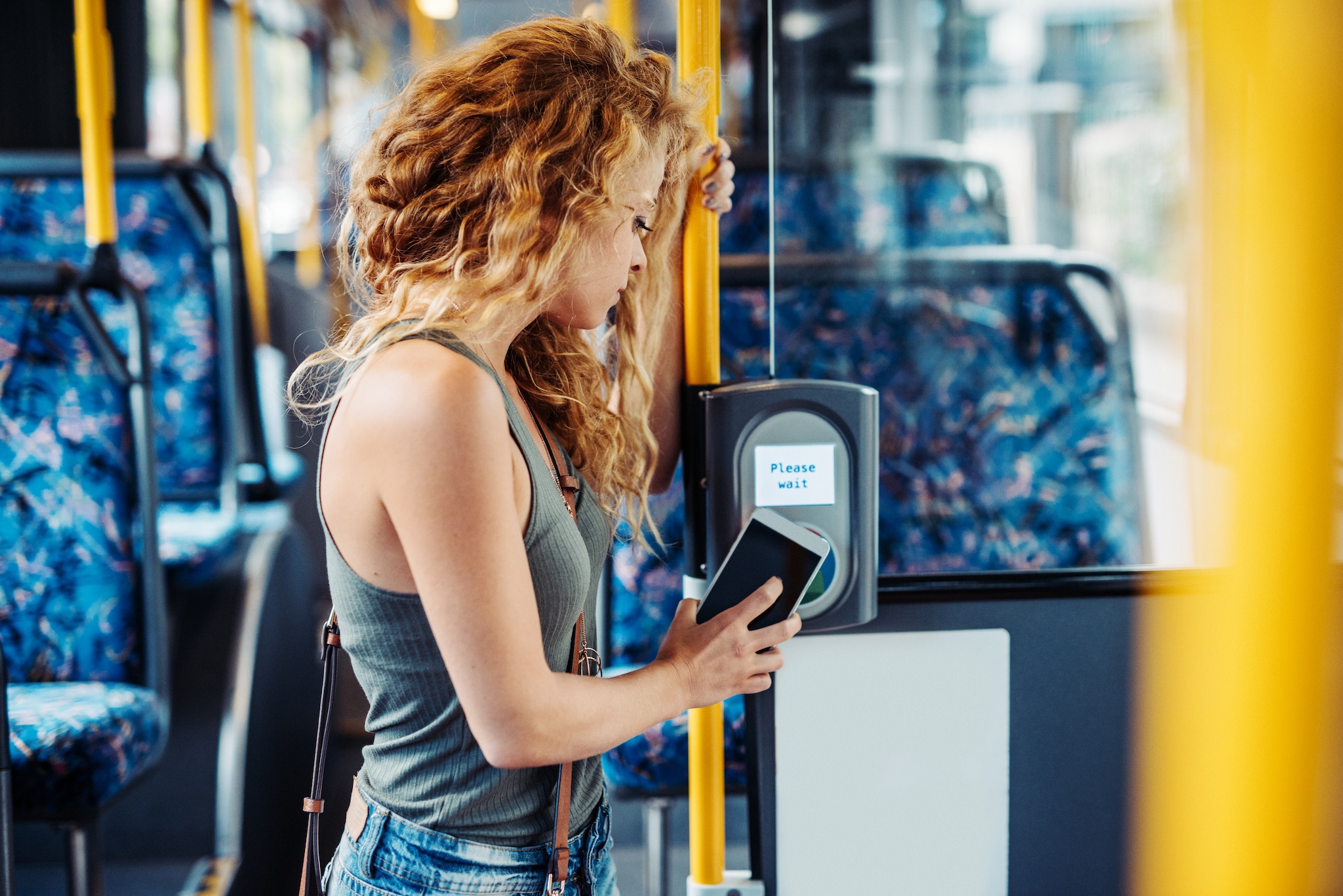 A lady using mobile wallet on the bus