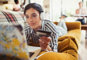 woman on the couch working on her laptop with headphones