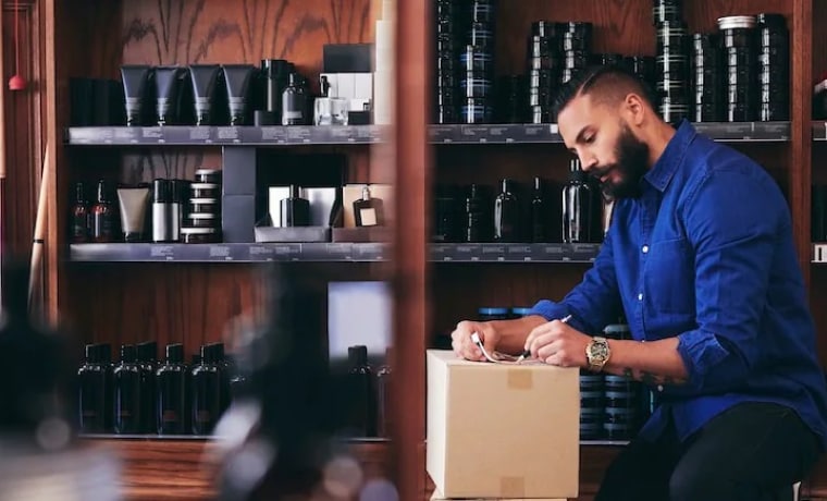 Small business owner writing address on package