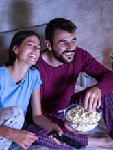 Couple eating popcorn in bed