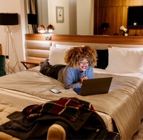 Individual working on hotel bed