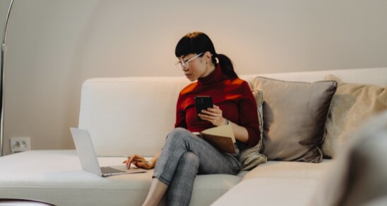 Individual working on laptop on couch