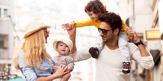 Two parents shopping with their young children. 