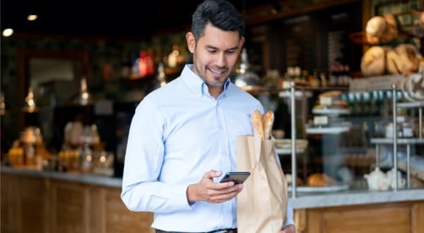  Man walking and receiving account alerts on Amex App