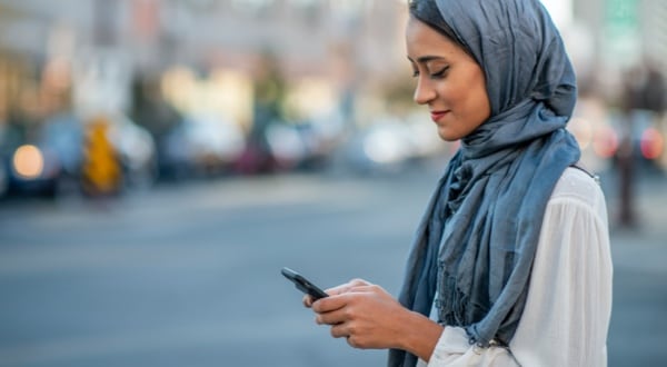 Woman standing outside searching through Amex Card transactions on Amex App