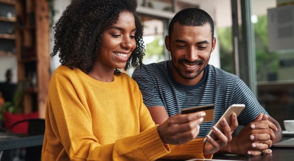 Couple at café adding additional Amex Cards to account using Amex App