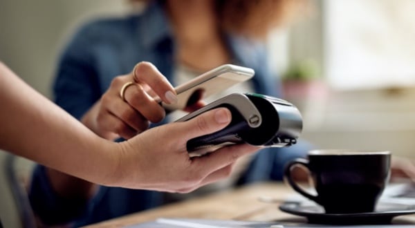  Woman tapping Amex Card to make payment