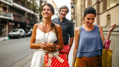 People walking down the street with shopping bags