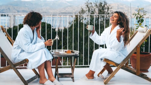 Two people drinking coffee on a hotel patio