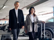 Two people in an airport parking lot.