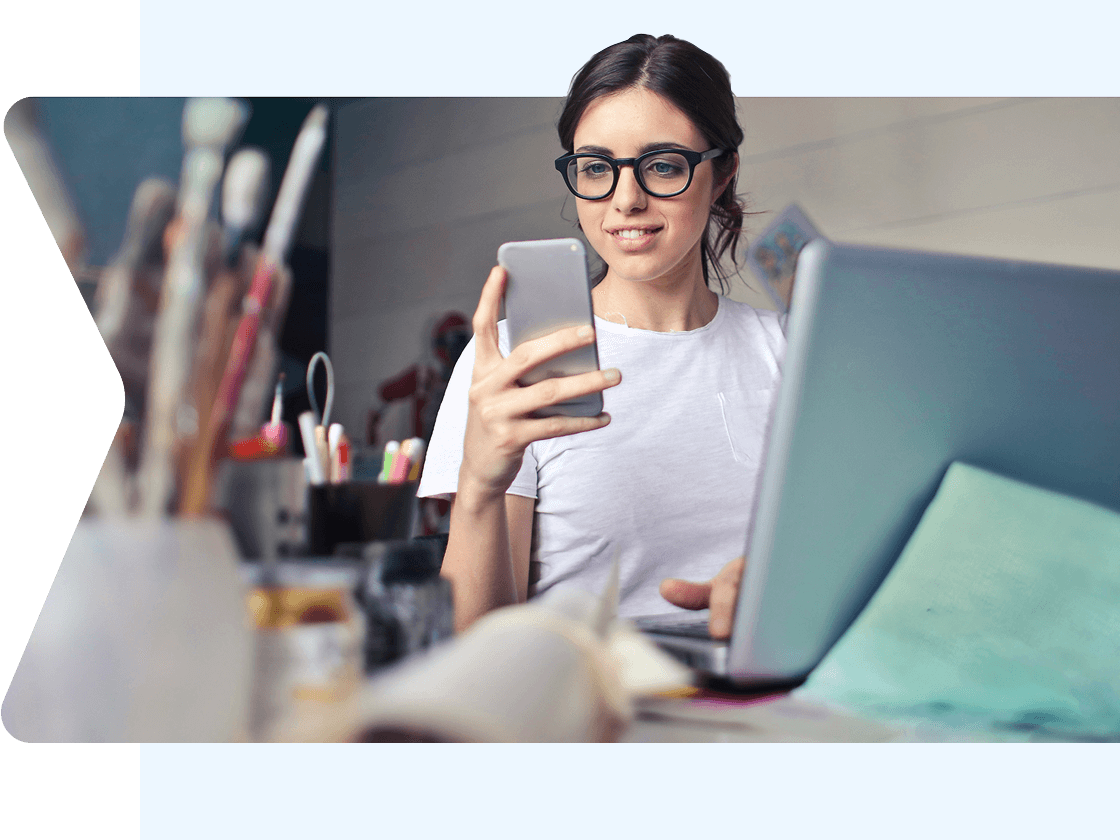 Person at work desk looking at mobile device
