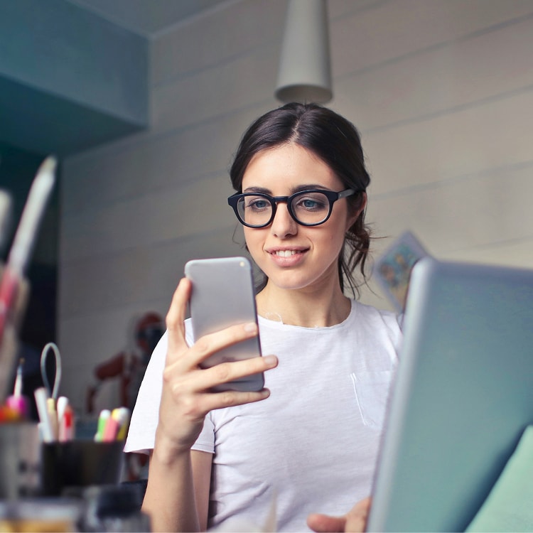 Person at work desk looking at mobile device