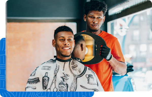  Good Business Pays logo is present next to a male African barber showing off the new haircut to a customer.