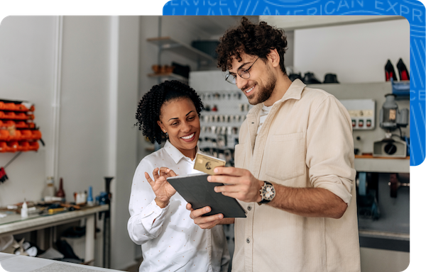 Two small business owners using their  tablet at their shoe repair workshop to look up their rate.
