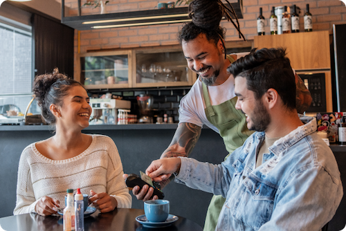 Small business owner holding payment terminal for customer paying with his credit card