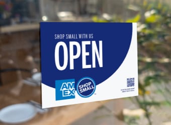 Open sign on storefront window with Amex and Shop Small logo