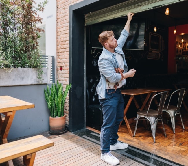Man opening storefront for the day