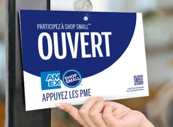 Open sign on storefront window with Amex and Shop Small logo