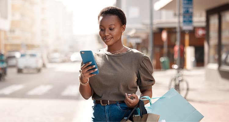 Personne sur appareil mobile avec sacs de magasinage