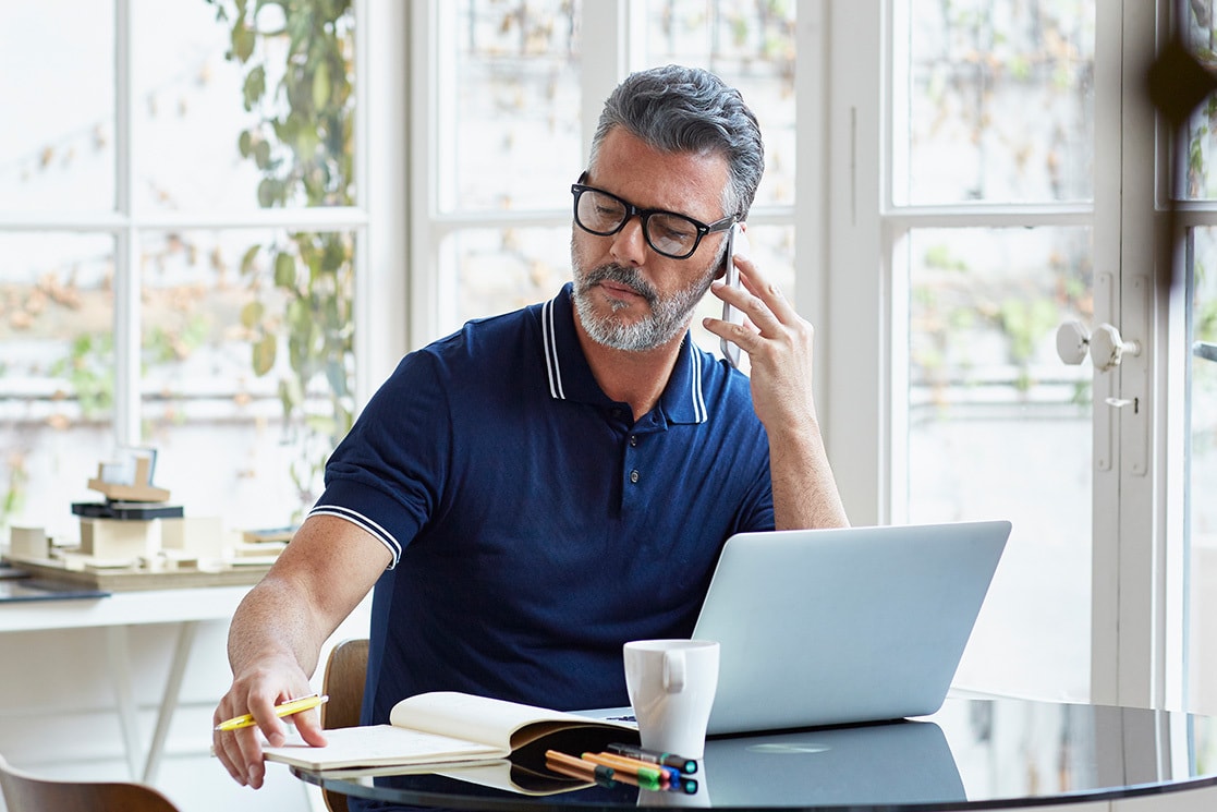 Person am Laptop, die gerade telefoniert