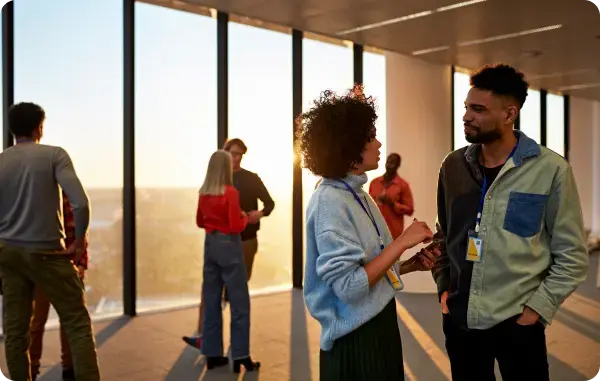 Zwei Personen unterhalten sich bei einer Business Veranstaltung in einem modernen Büro