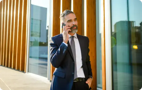 Geschäftsmann telefoniert mit seinem Smartphone vor einem modernen Gebäude