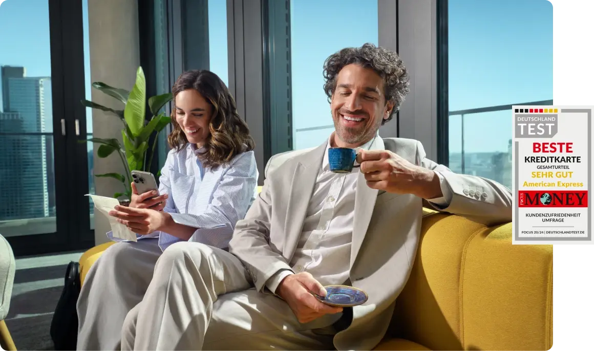 Zwei Geschäftsreisende entspannen in einer modernen Lounge. Neben dem Bild ist das Focus Money Siegel „Beste Kreditkarte – Sehr gut” für American Express zu sehen.
