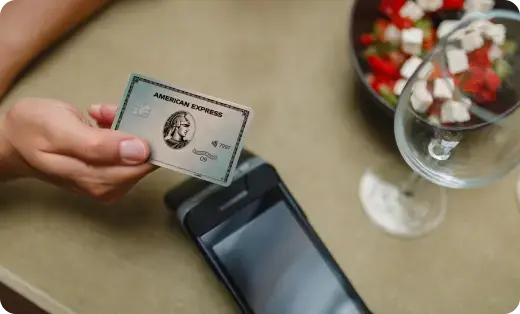 Person hält eine Platinum Plus Card aus Plastik beim Bezahlen des Essens in der Hand.