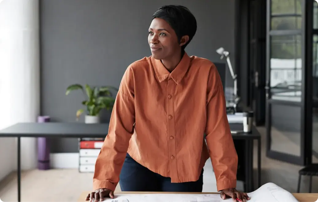 Unternehmerin im Büro blickt nach vorne – Symbol für Erfolg mit den American Express Business Karten.