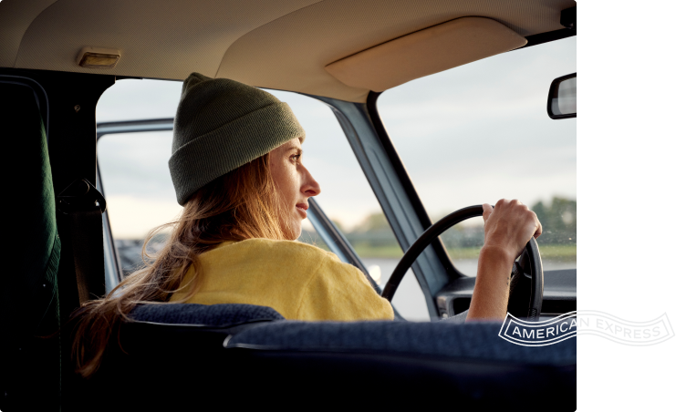 woman with a hat driving a car