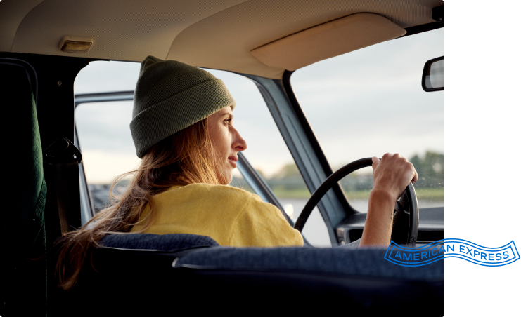 woman with a hat driving a car