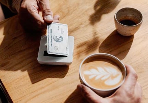 Person in einem Café bezahlt eine Kaffee kontaktlos.