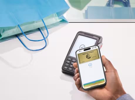 Eine Person bezahlt in einem Geschäft per Wallet App mit American Express