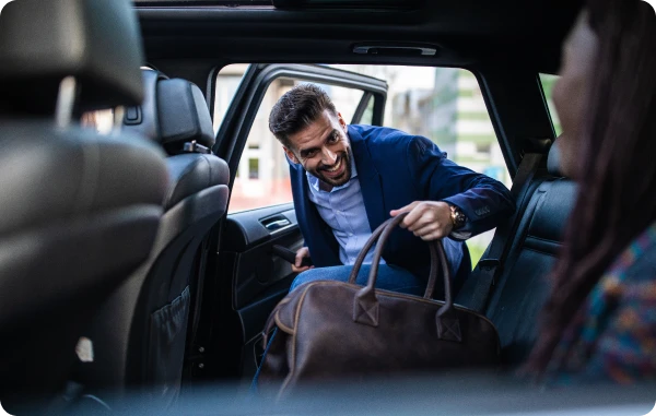 Europaweiter Kfz-Schutzbrief - Frau spricht mit Kind auf dem Rücksitz eines Autos, geöffnetes Fenster im Hintergrund.