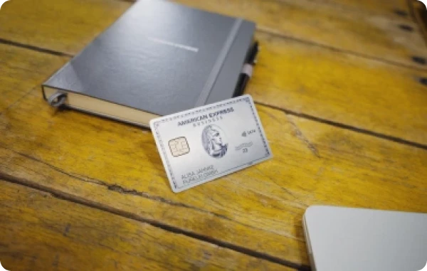 Verlängertes Zahlungsziel - American Express Karte liegt auf einem hölzernen Tisch neben einem Laptop.