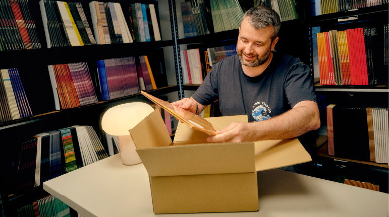 Record store owner holding vinyl records in a shop