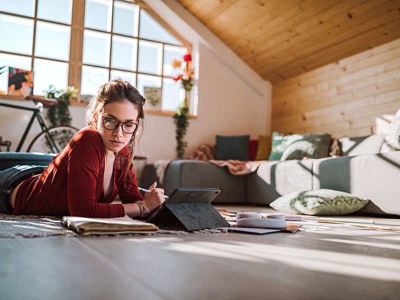 Woman working with tablet in apartment.