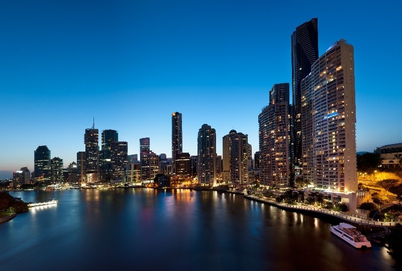 Brisbane skyline illuminated at twilight with reflections over the Brisbane River.