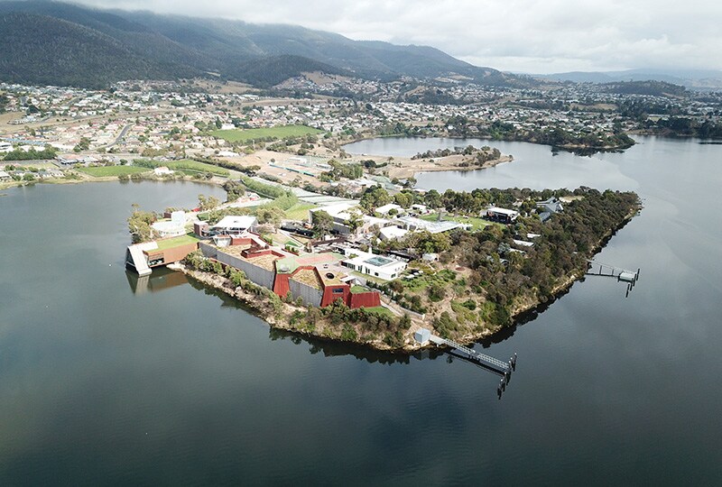 Aerial view of Hobart’s riverfront peninsula surrounded by calm water and rolling hills.