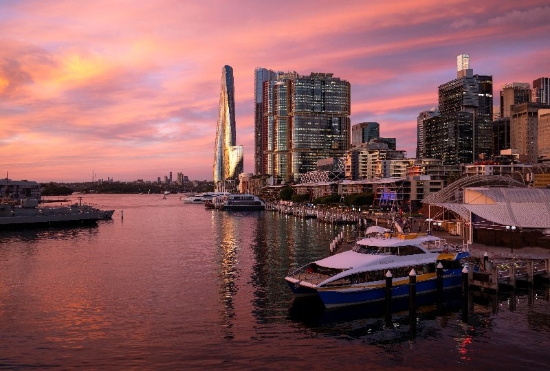 Barangaroo waterfront at dusk with modern skyscrapers and moored yachts.