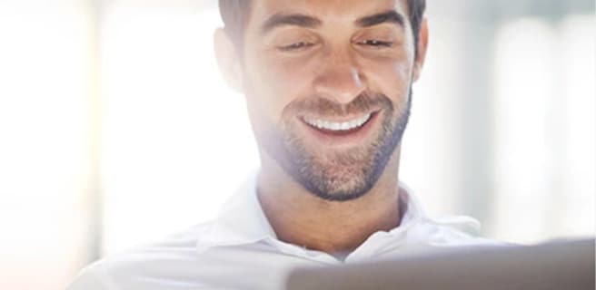man smiling down at his laptop