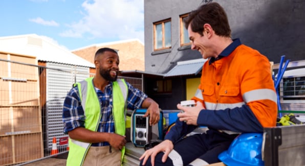 Two males dressed in high visibility workwear on a construction site