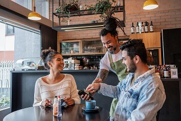 A lady making payment using her phone after grocery shopping.