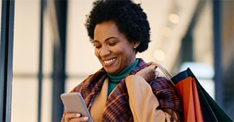 Woman similing on phone with shopping bags       