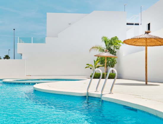 Pool with white buildings and palm trees 