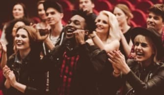 Woman leading through crowd, looking back and smiling
