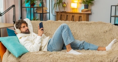 Personne relaxant sur un sofa en magasinant sur son téléphone.